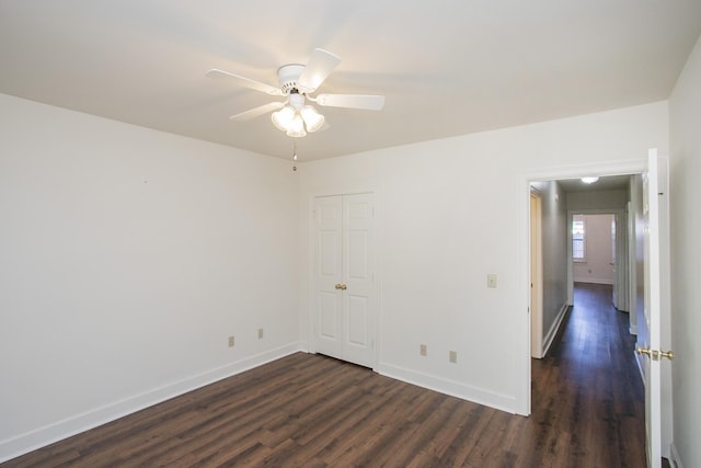 unfurnished bedroom featuring a closet, baseboards, and dark wood-type flooring