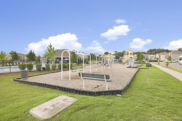 community jungle gym featuring a residential view, fence, and a lawn