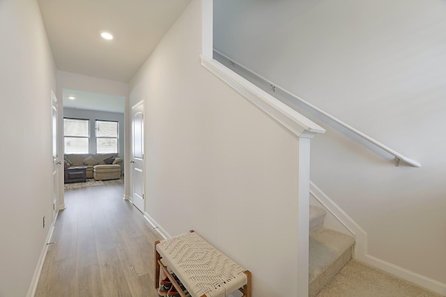 hallway featuring recessed lighting, stairway, baseboards, and wood finished floors