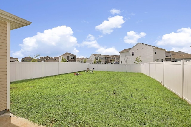 view of yard with a fenced backyard and a residential view