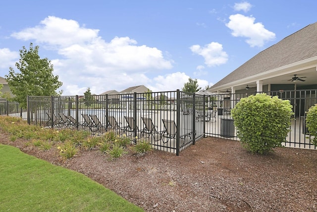 view of gate featuring a ceiling fan and fence