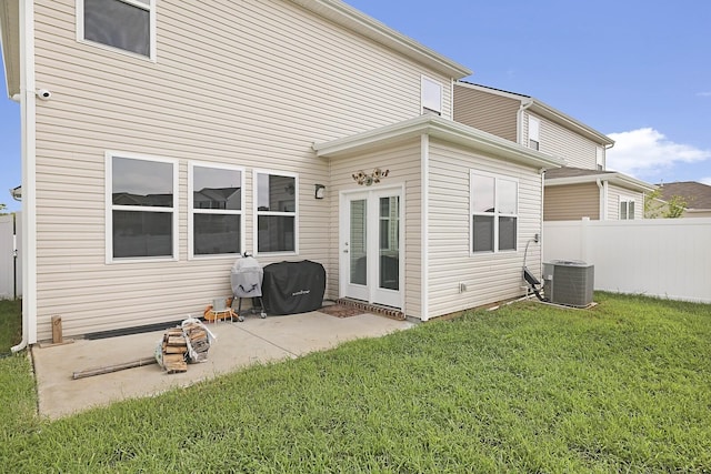 rear view of property with a patio area, a yard, fence, and central air condition unit