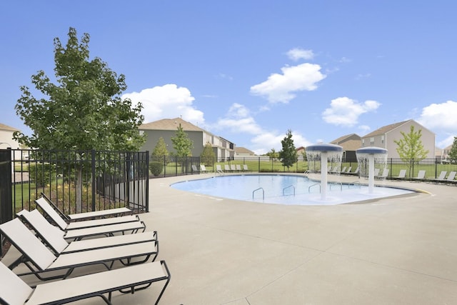 pool with a patio area, a residential view, and fence