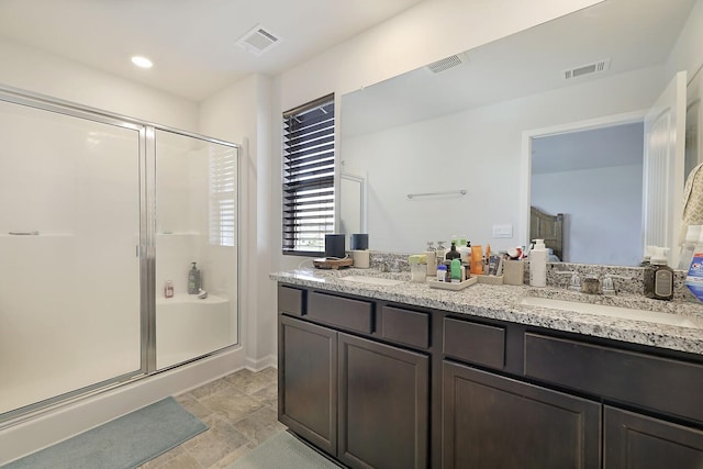 bathroom with a stall shower, visible vents, a sink, and double vanity