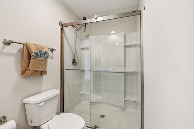 bathroom featuring a shower stall and toilet