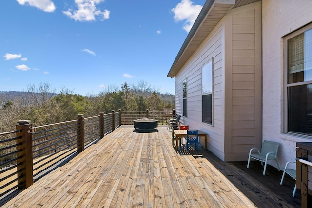 deck featuring a fire pit and a view of trees