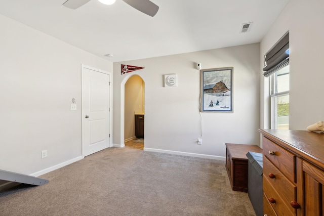 interior space with visible vents, arched walkways, baseboards, and light colored carpet