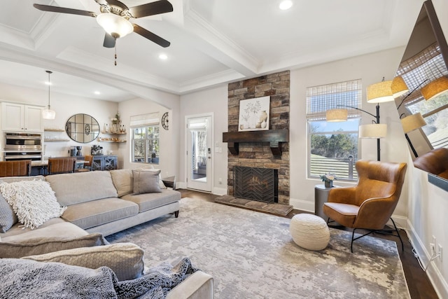 living area with a fireplace, ornamental molding, beam ceiling, and wood finished floors