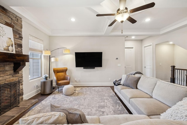 living room featuring dark wood-style floors, a fireplace, crown molding, and baseboards