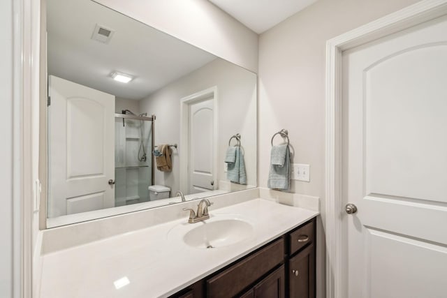 full bath featuring a shower, visible vents, vanity, and toilet