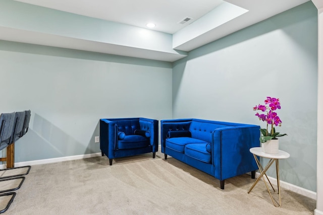 living area with carpet, visible vents, and baseboards