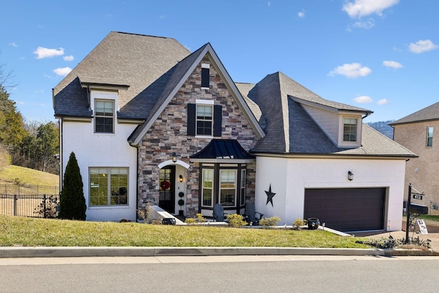 view of front of house with an attached garage, stone siding, fence, and a front yard