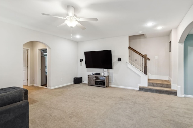 living area featuring carpet, stairs, arched walkways, and baseboards