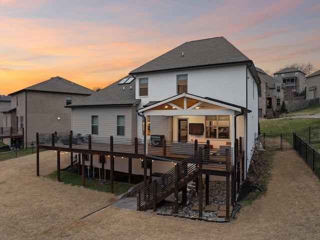 back of property featuring roof with shingles, a fenced backyard, a wooden deck, and stairs