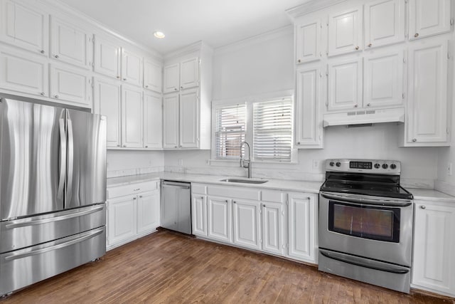 kitchen featuring under cabinet range hood, white cabinetry, appliances with stainless steel finishes, and a sink