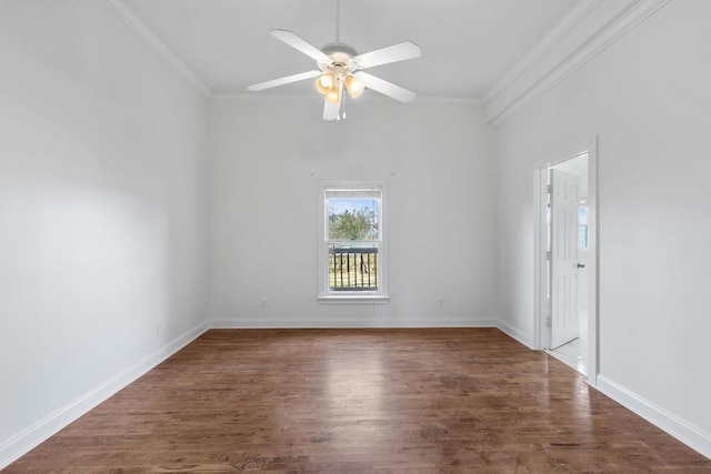 spare room with ornamental molding, wood finished floors, a ceiling fan, and baseboards