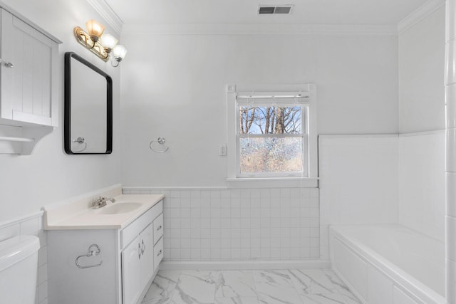 bathroom featuring marble finish floor, crown molding, visible vents, toilet, and wainscoting