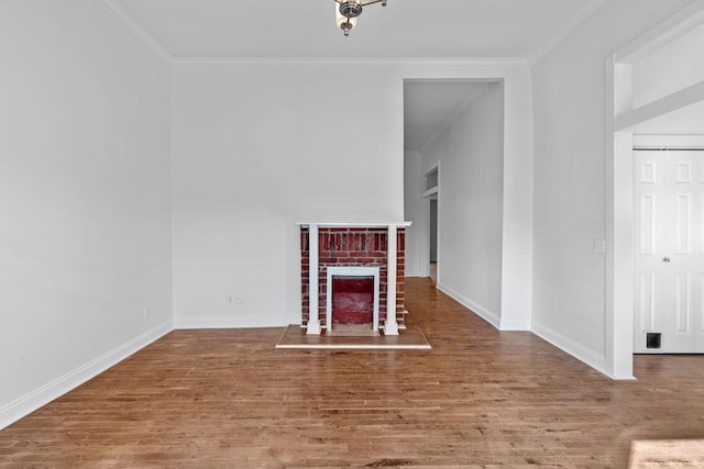 unfurnished living room with ornamental molding, a fireplace, baseboards, and wood finished floors