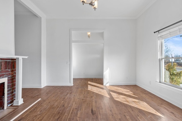 unfurnished living room featuring a brick fireplace, plenty of natural light, ornamental molding, and wood finished floors