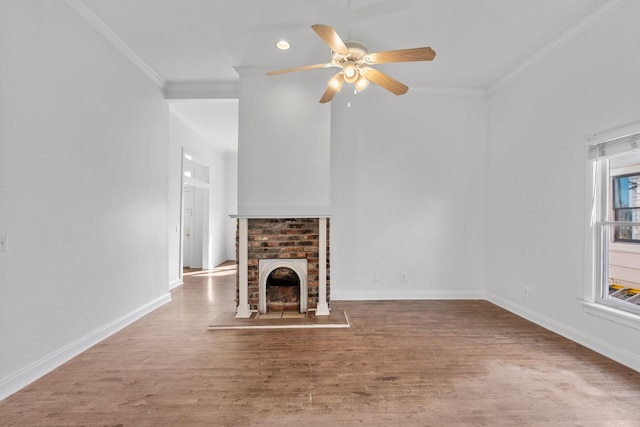 unfurnished living room with baseboards, a ceiling fan, wood finished floors, crown molding, and a brick fireplace