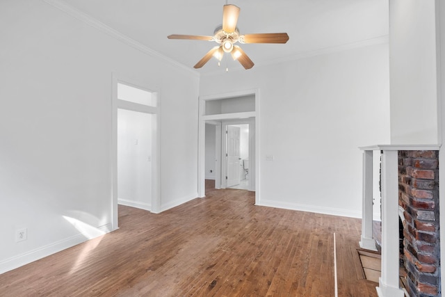 unfurnished living room with ornamental molding, wood finished floors, a ceiling fan, and baseboards