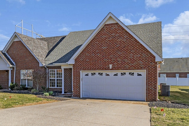 traditional-style home featuring a garage, concrete driveway, roof with shingles, central AC, and brick siding