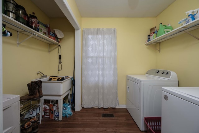 laundry room with dark wood finished floors, visible vents, and independent washer and dryer