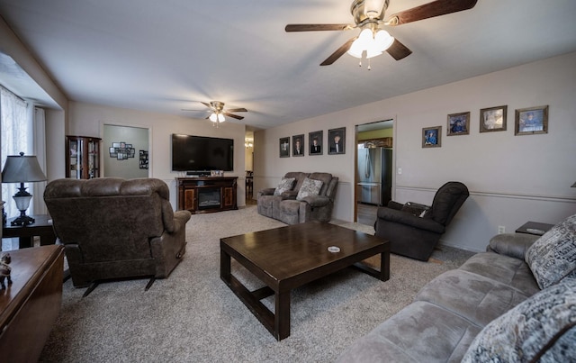 living room featuring light carpet, ceiling fan, and a fireplace