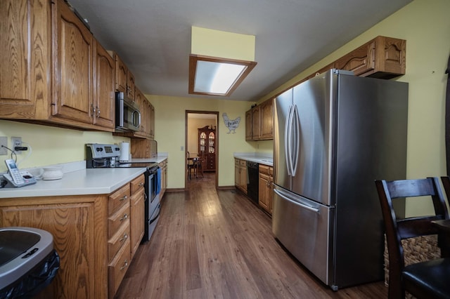 kitchen with stainless steel appliances, light countertops, dark wood-style flooring, and brown cabinetry