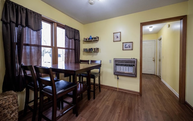 dining room with baseboards, heating unit, and wood finished floors