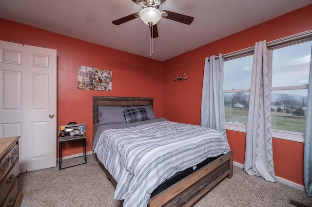 bedroom with baseboards, visible vents, a ceiling fan, and light colored carpet