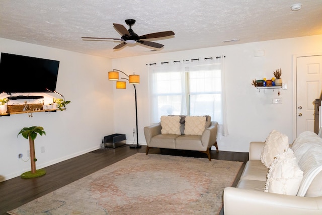 living room with visible vents, a ceiling fan, a textured ceiling, wood finished floors, and baseboards