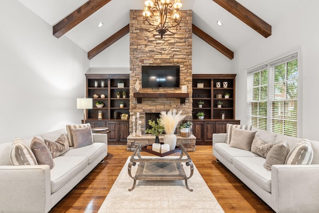 living area with an inviting chandelier, a fireplace, high vaulted ceiling, and wood finished floors