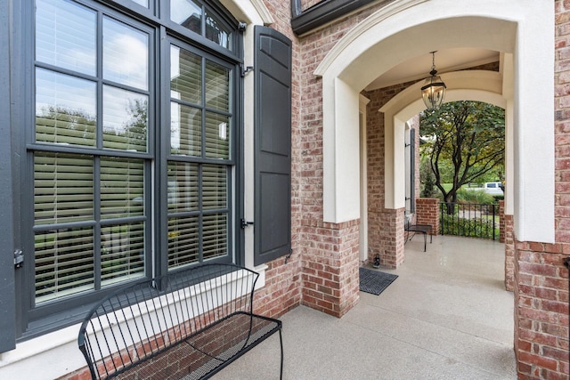 entrance to property with covered porch and brick siding