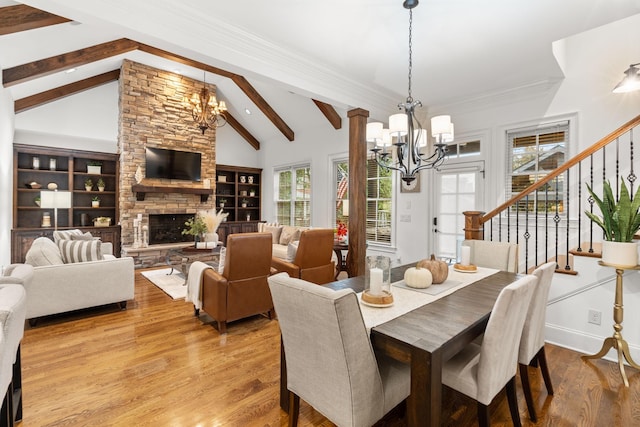 dining area with stairs, beamed ceiling, a notable chandelier, and wood finished floors