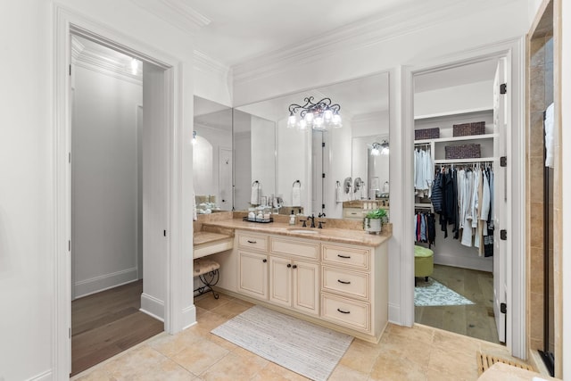 full bath with ornamental molding, a walk in closet, vanity, and tile patterned floors