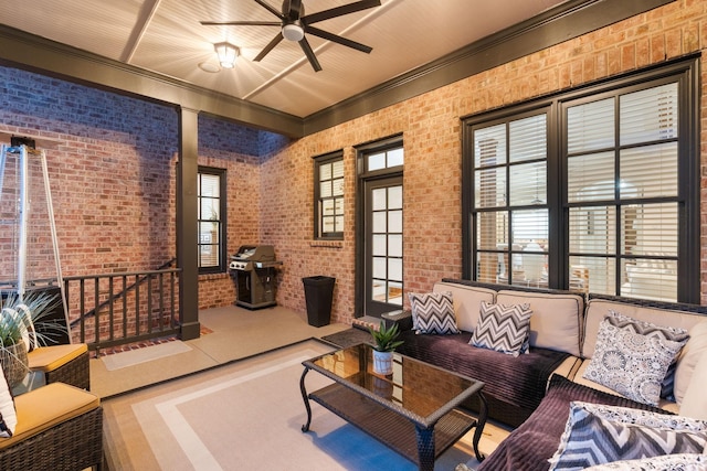 living room featuring brick wall and a ceiling fan