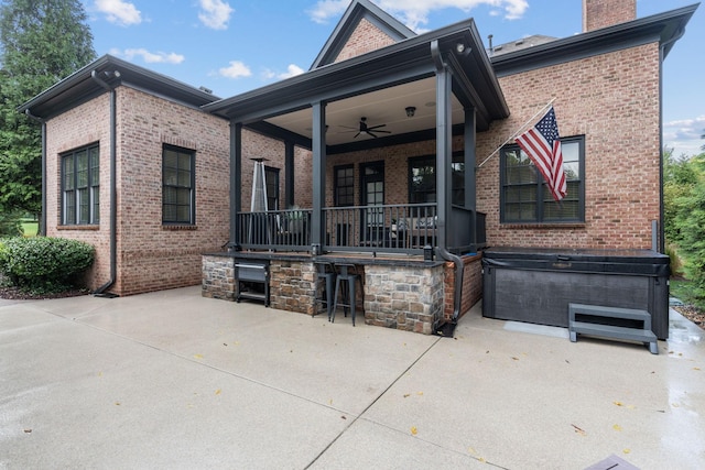 back of property featuring a ceiling fan, brick siding, a patio, and outdoor dry bar