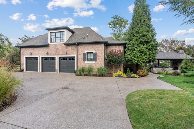 view of front facade featuring a garage, concrete driveway, brick siding, and a front yard