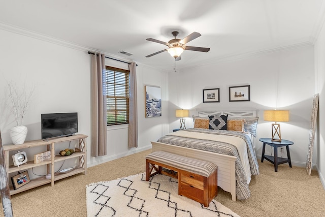 carpeted bedroom with baseboards, a ceiling fan, visible vents, and crown molding