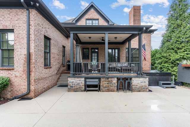 back of house with a ceiling fan, a patio area, brick siding, and a chimney