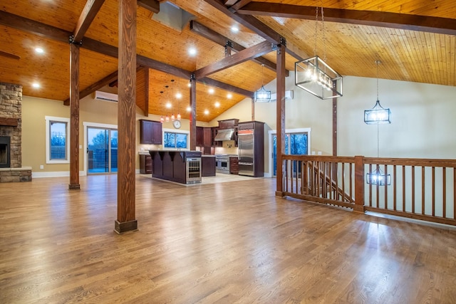 living room with beam ceiling, wood ceiling, a stone fireplace, high vaulted ceiling, and light wood-type flooring