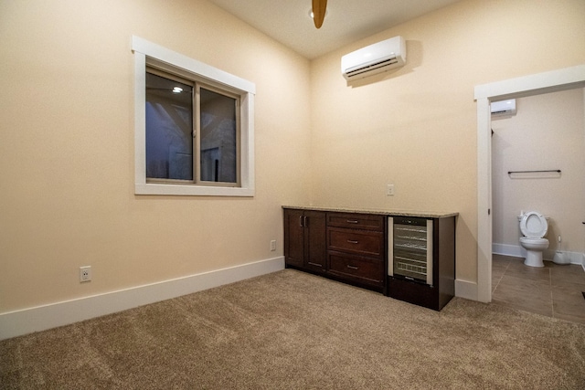 interior space with light colored carpet, a wall mounted air conditioner, baseboards, and wine cooler