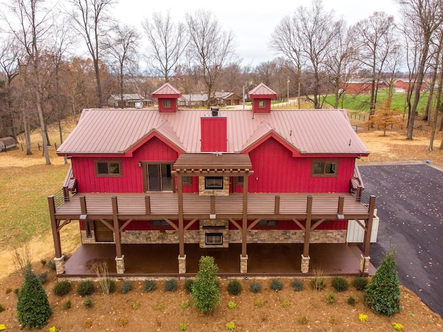 view of front facade with metal roof, a deck, and board and batten siding