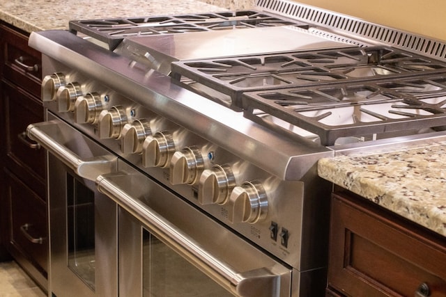 room details with range with two ovens and dark brown cabinetry