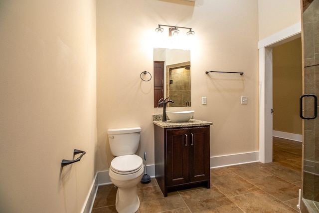 bathroom with baseboards, vanity, and toilet