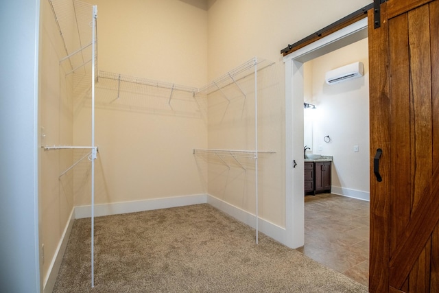 spacious closet with a wall mounted air conditioner, carpet flooring, and a barn door