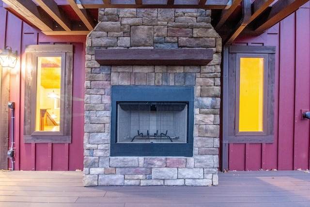 details with stone siding, board and batten siding, and an outdoor stone fireplace