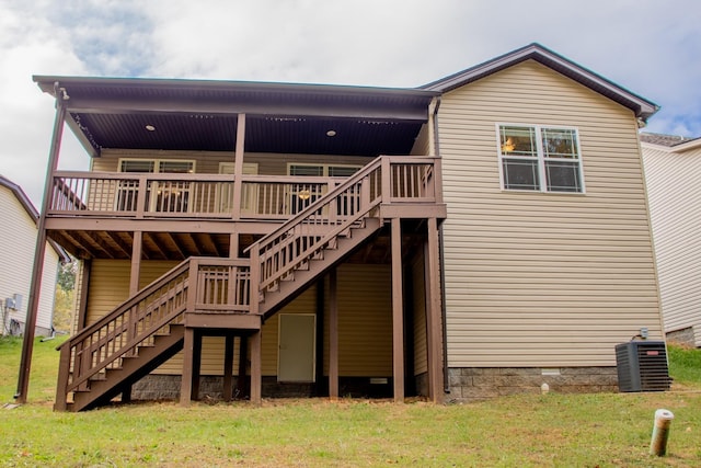 rear view of house with central air condition unit, a wooden deck, stairway, and a yard