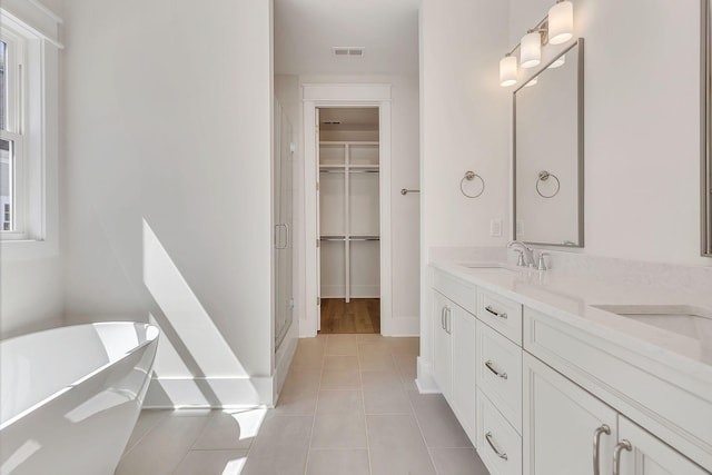 full bath featuring double vanity, a soaking tub, visible vents, a sink, and a shower stall